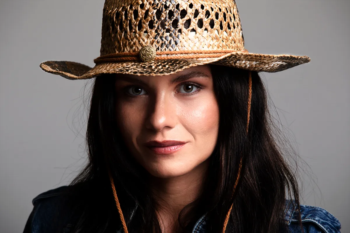 Book fotografico donna a Milano, primo piano con cappello in paglia in studio