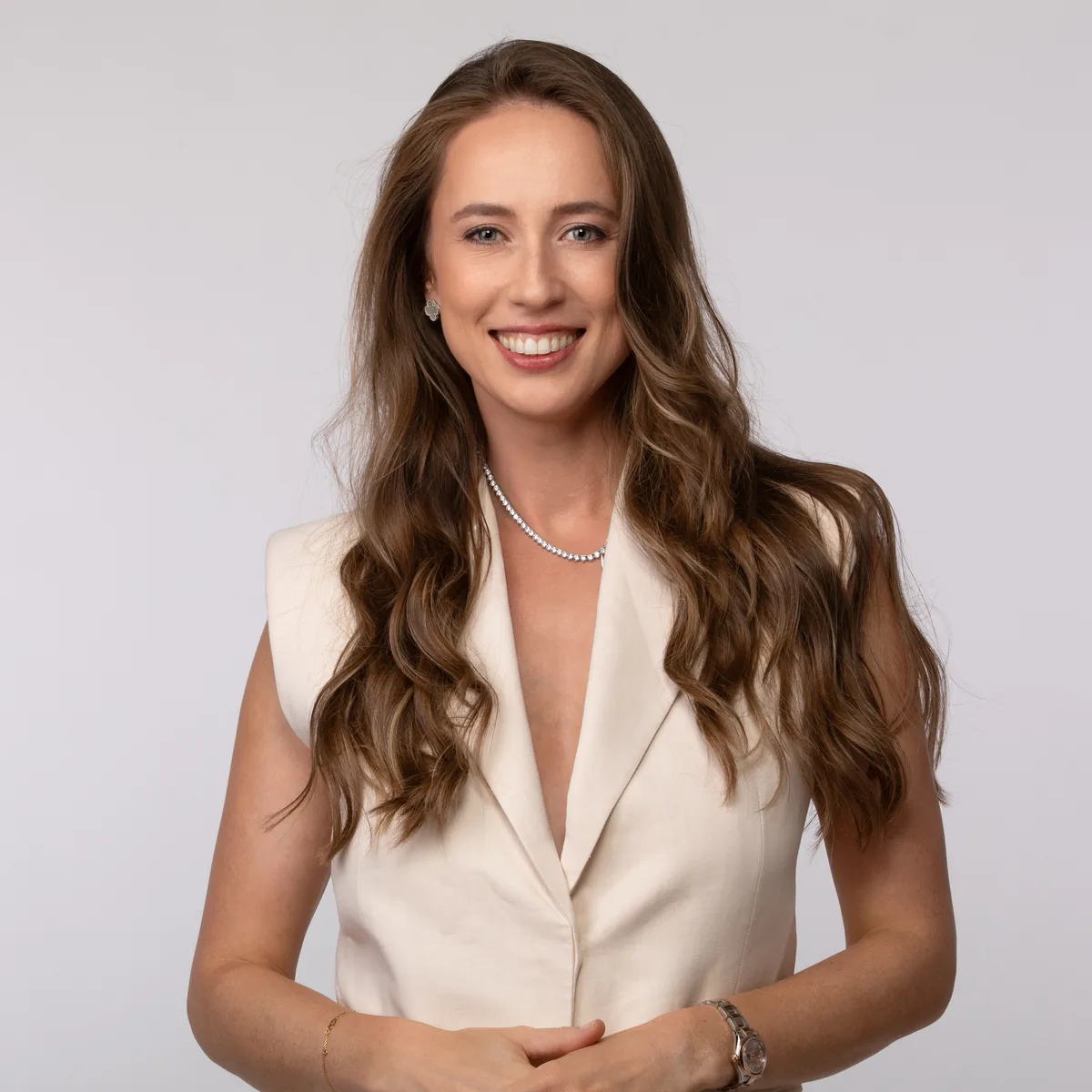 Headshot LinkedIn di una donna in blazer avorio su fondo chiaro, ritratto in studio a Milano